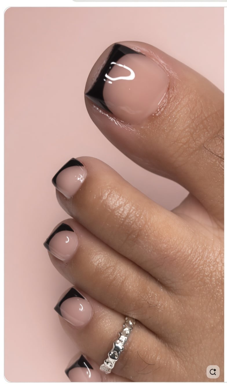 Luxury black French tip toe nails on blush pink satin with a glossy finish