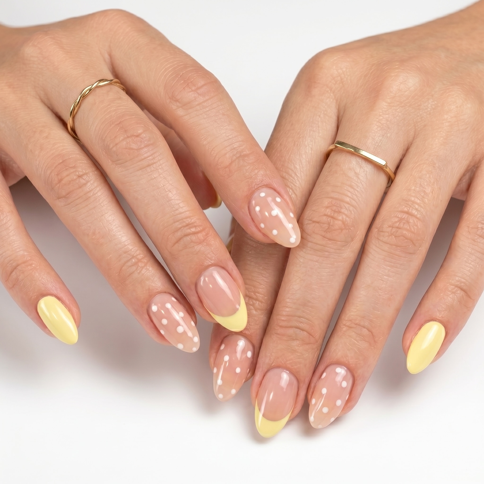 Nude nails with butter yellow French tips and tiny white daisy accents