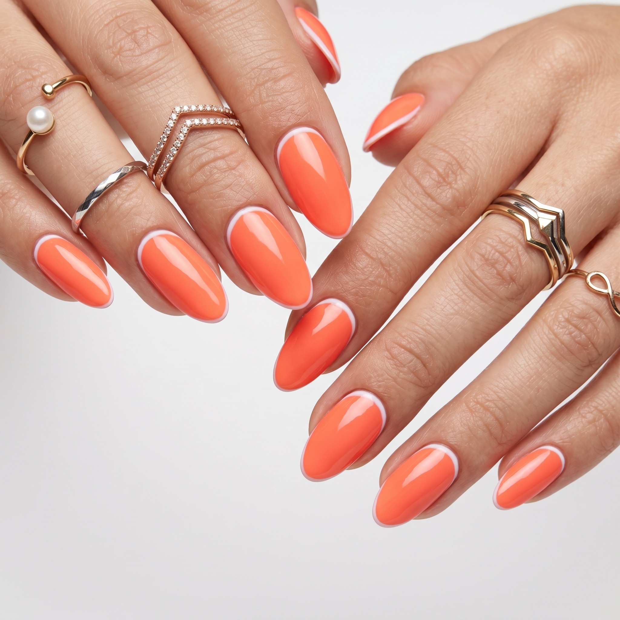 Almond nails with bright coral French tips and a glossy nude base