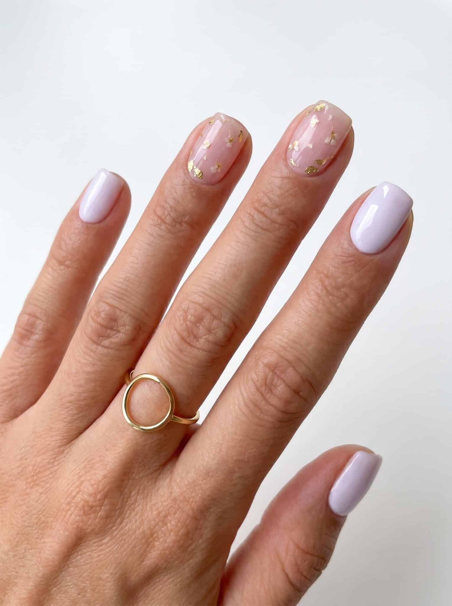 Short pearly lavender nails with gold foil and tiny floral accents