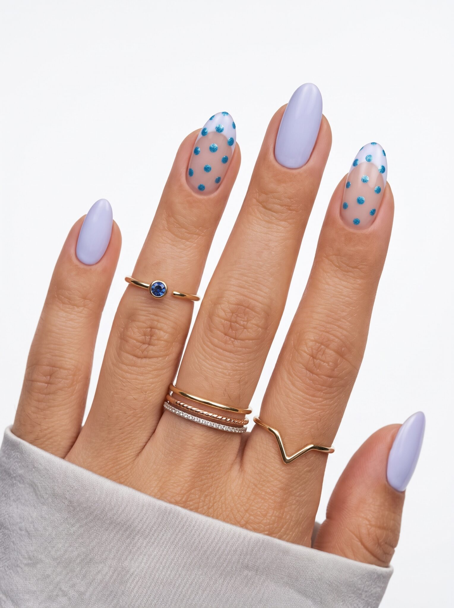 Pale lilac nails with scattered dark purple and black polka dots