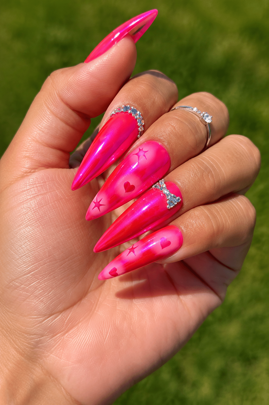 Bright pink summer nails with floral accent details and a glossy finish