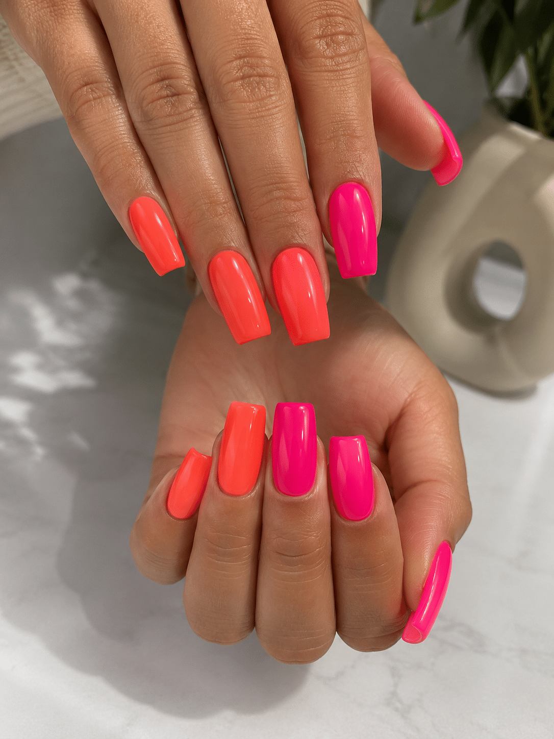 Bright pink and orange summer nails with a warm sunset-inspired finish