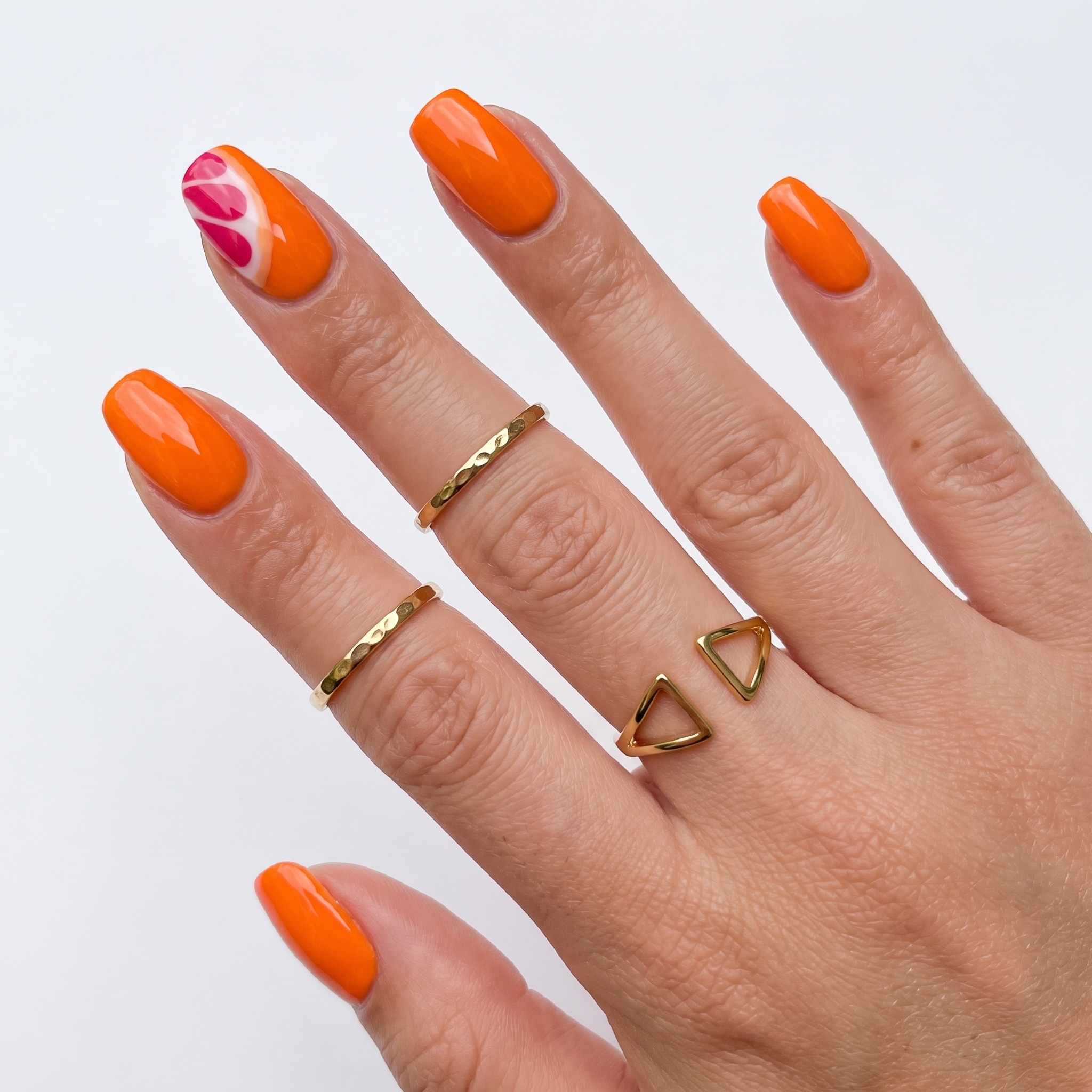 Orange coral almond nails with small pink accent details
