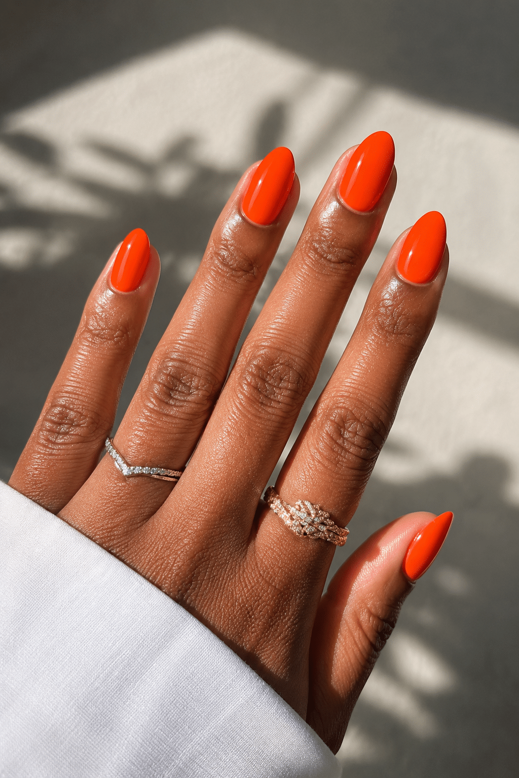Glossy orange coral nails on medium almond shape