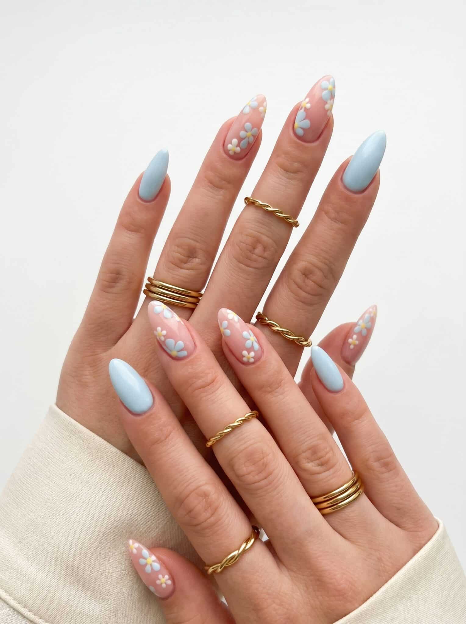 Pastel blue nails with tiny floral accents and soft colorful details