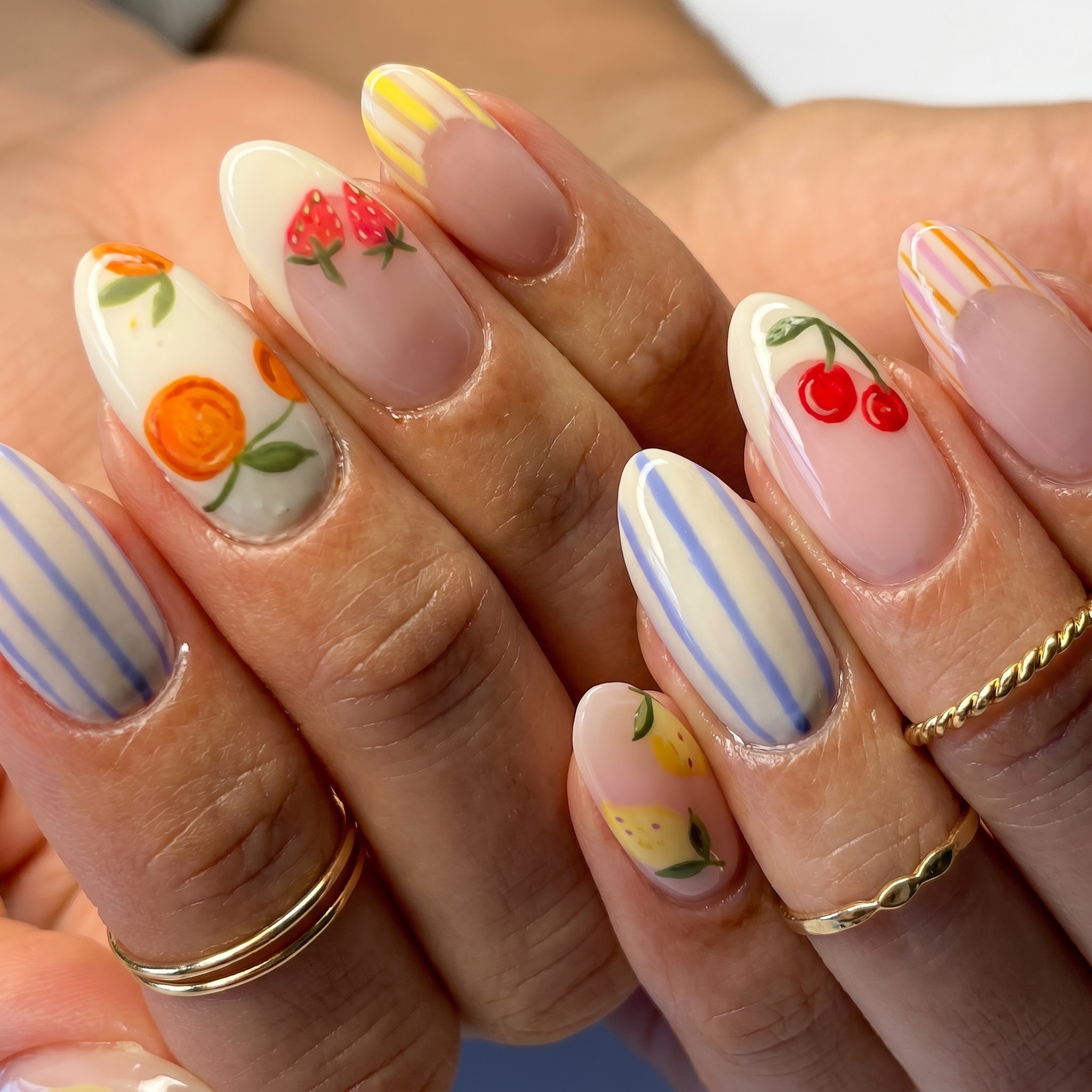 Almond nails with pastel blue, lilac, pink, and soft green colorblock French tips