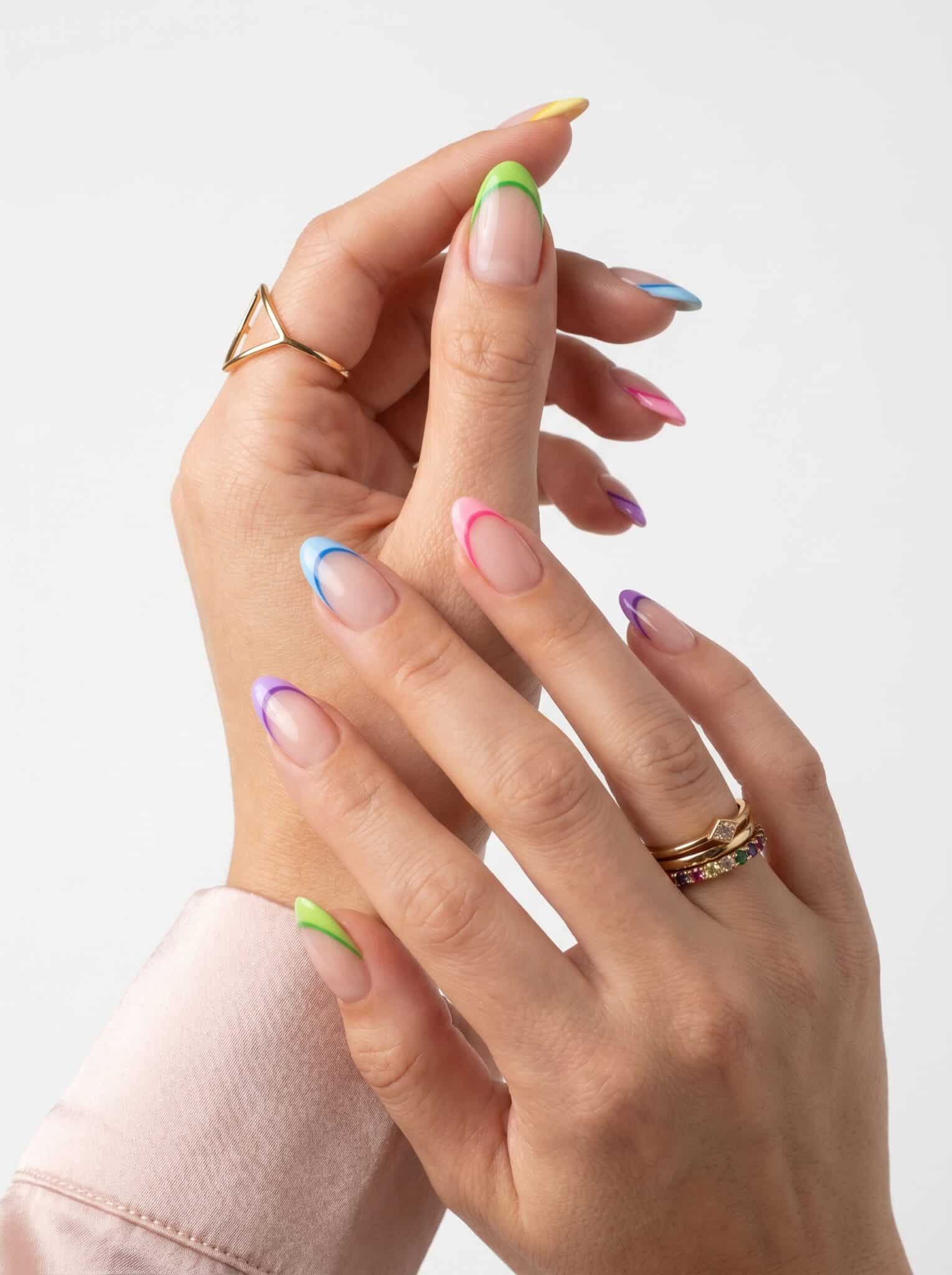 Nude nails with pastel rainbow micro French tips in pink, purple, yellow, and green