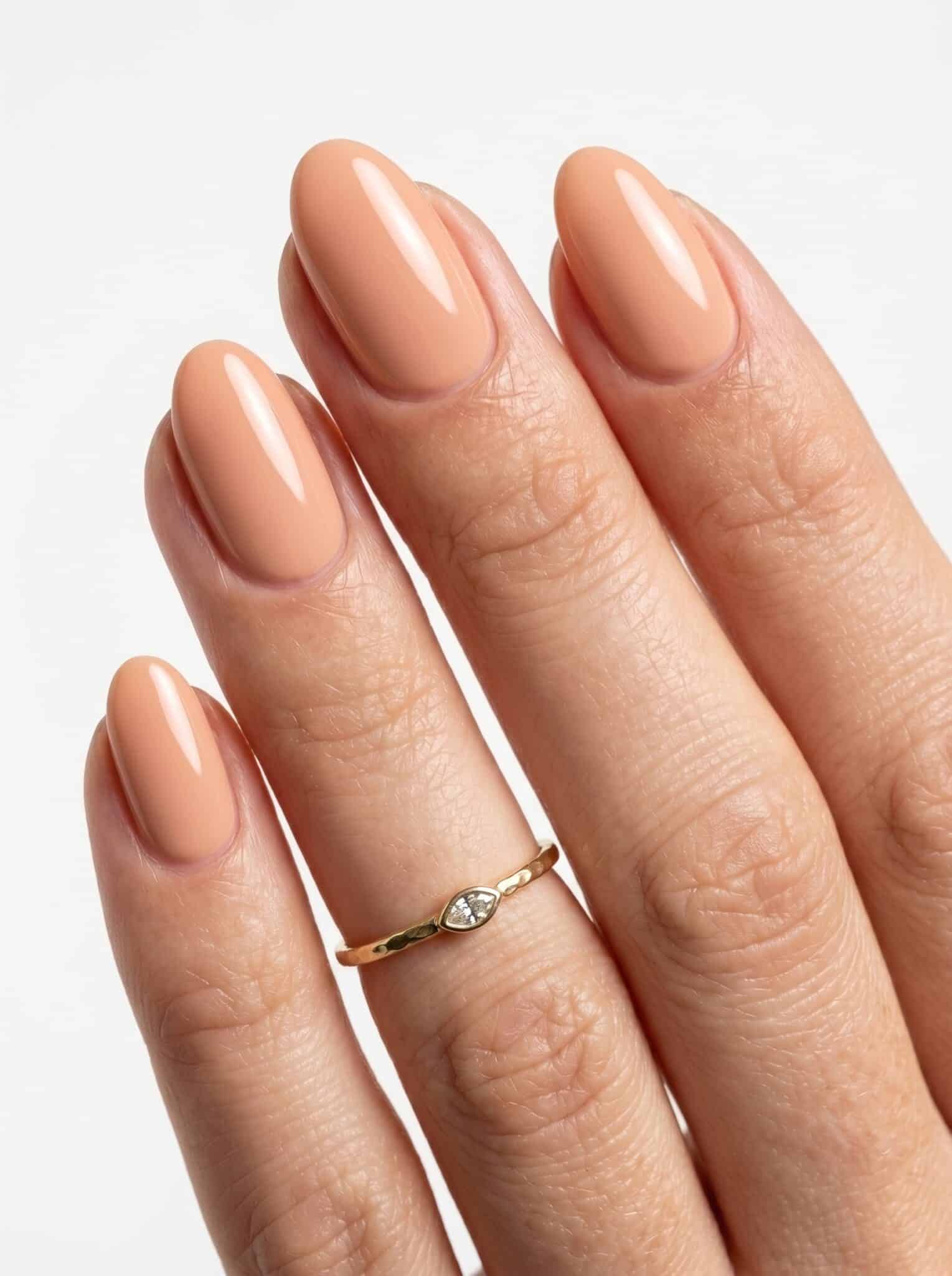 Glossy peachy nude almond nails with a smooth natural finish