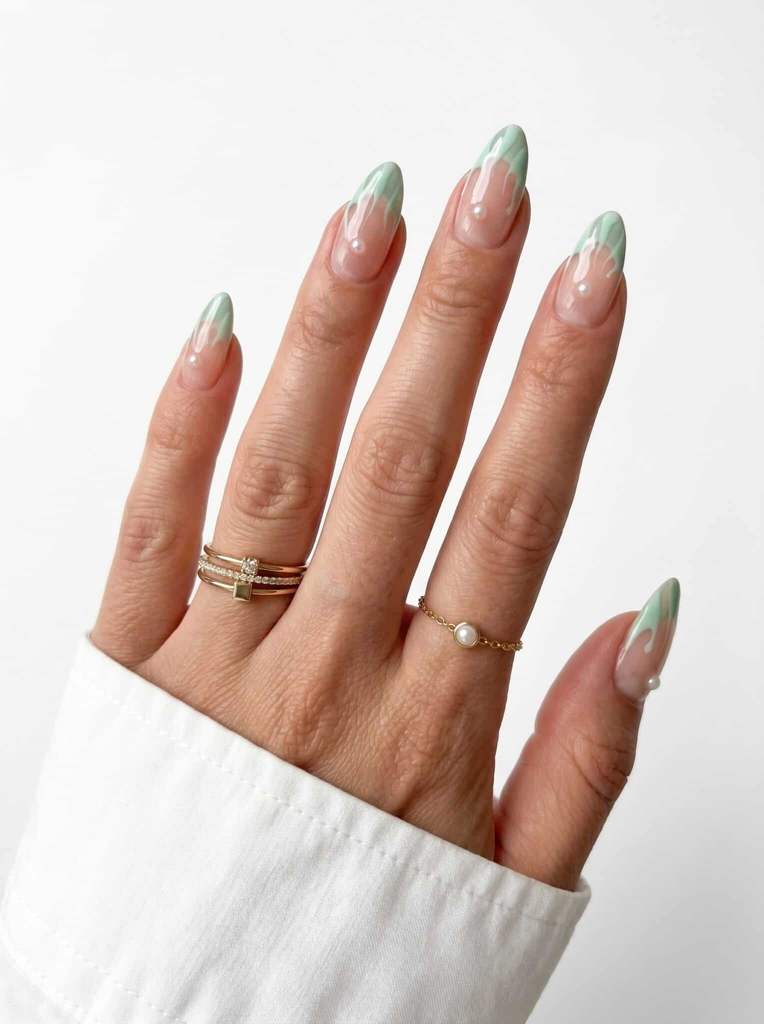 Almond nails with slim sage green French tips