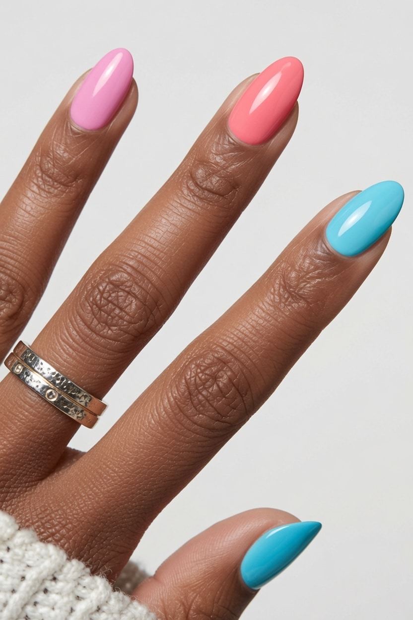 Short nails painted in soft pastel pink, purple, and blue shades
