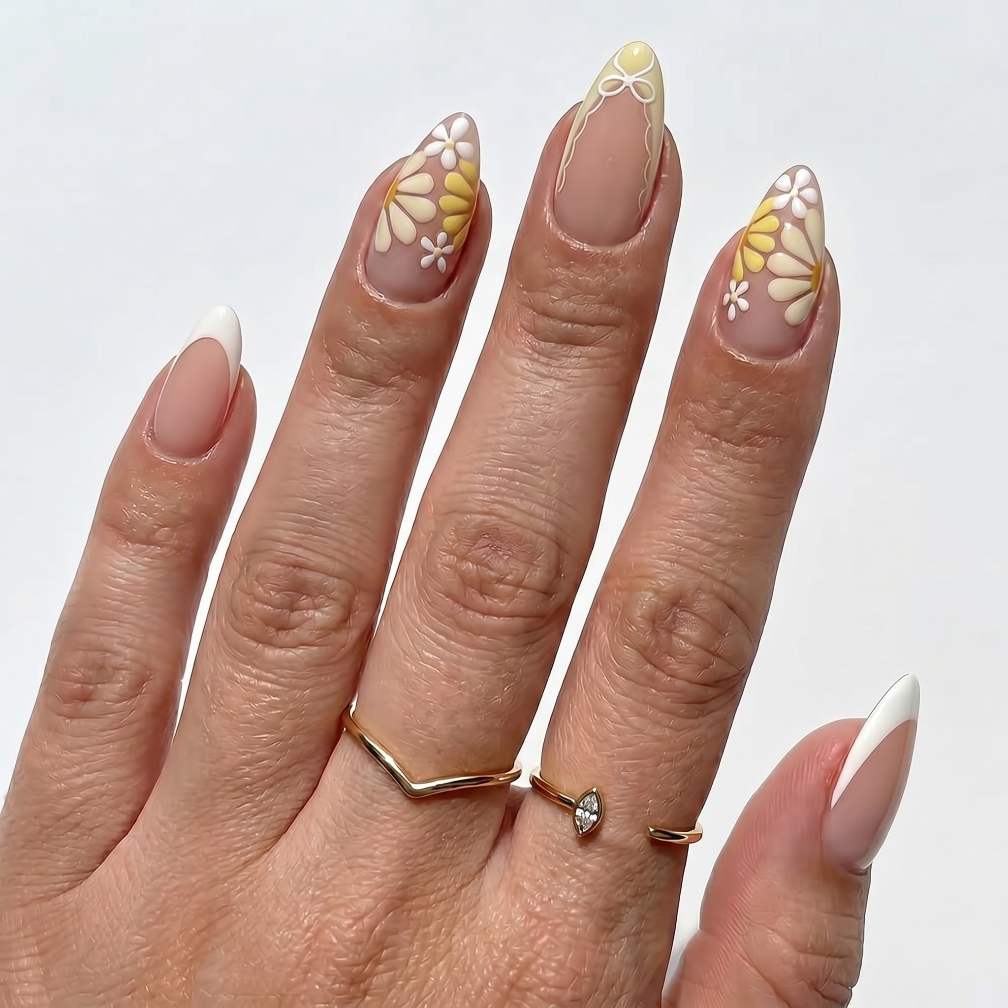 Nude nails with yellow French tips and white daisy nail art
