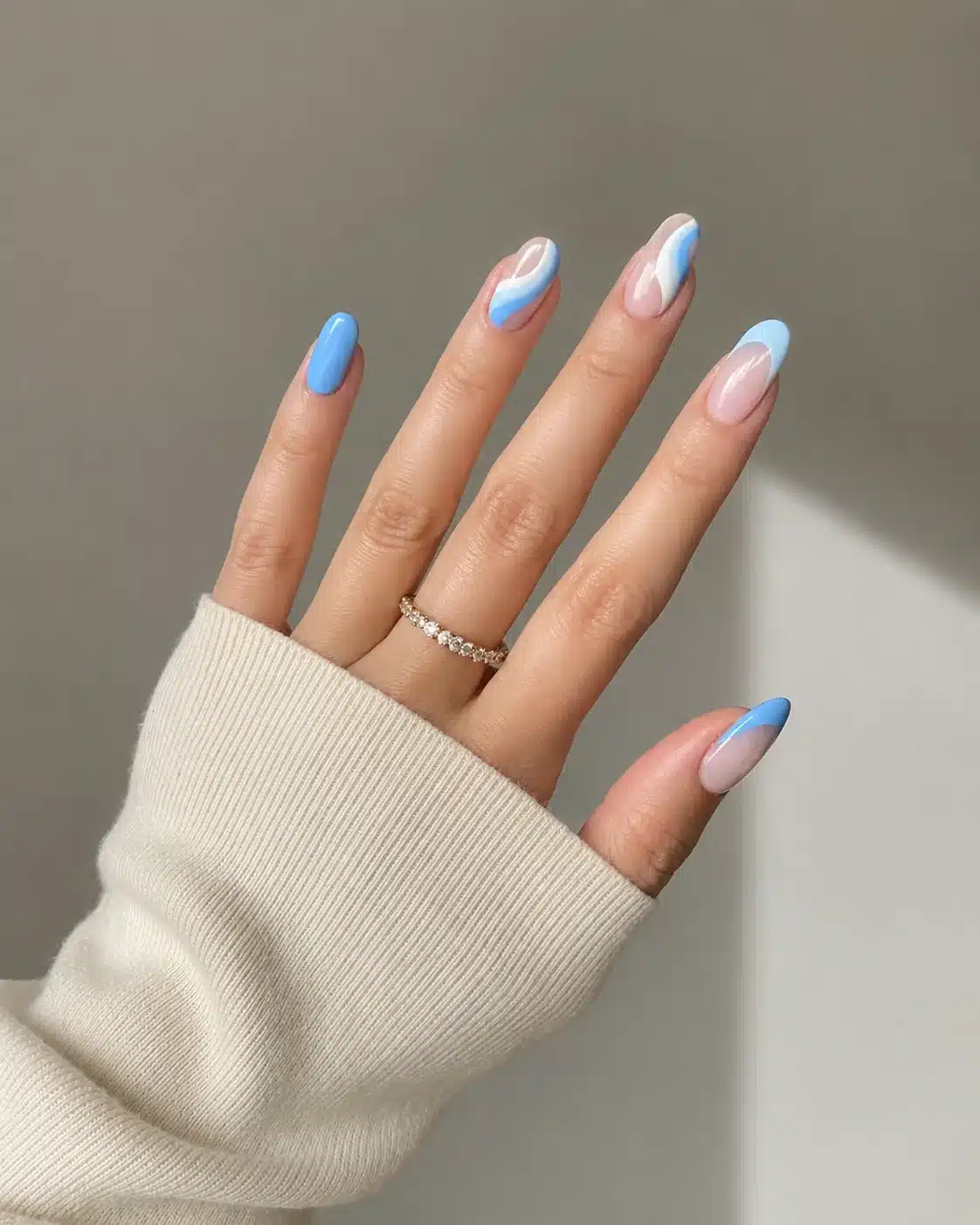Baby blue French tip nails on a sheer base