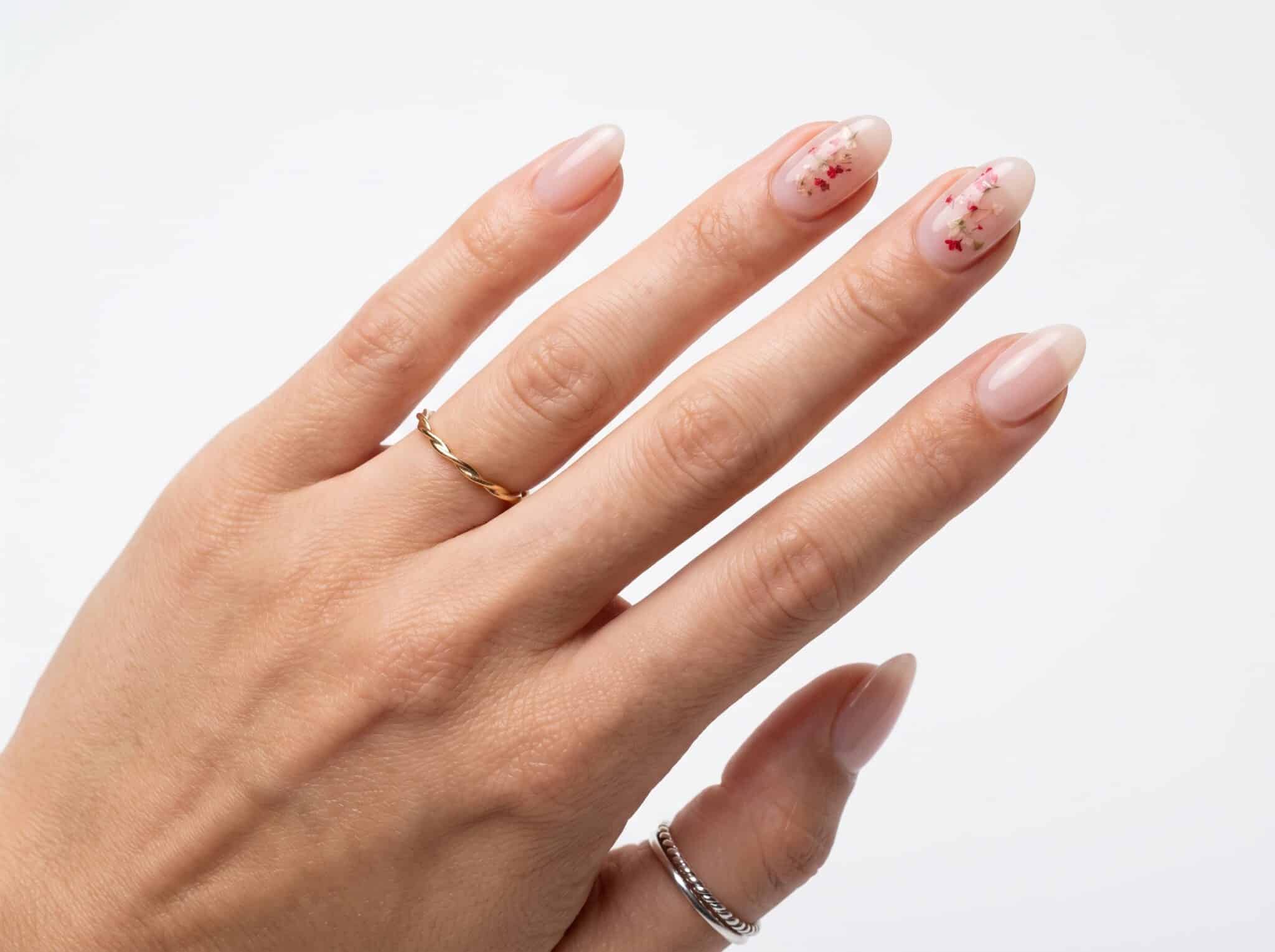 Clean nude glossy summer nails with subtle flower accent details