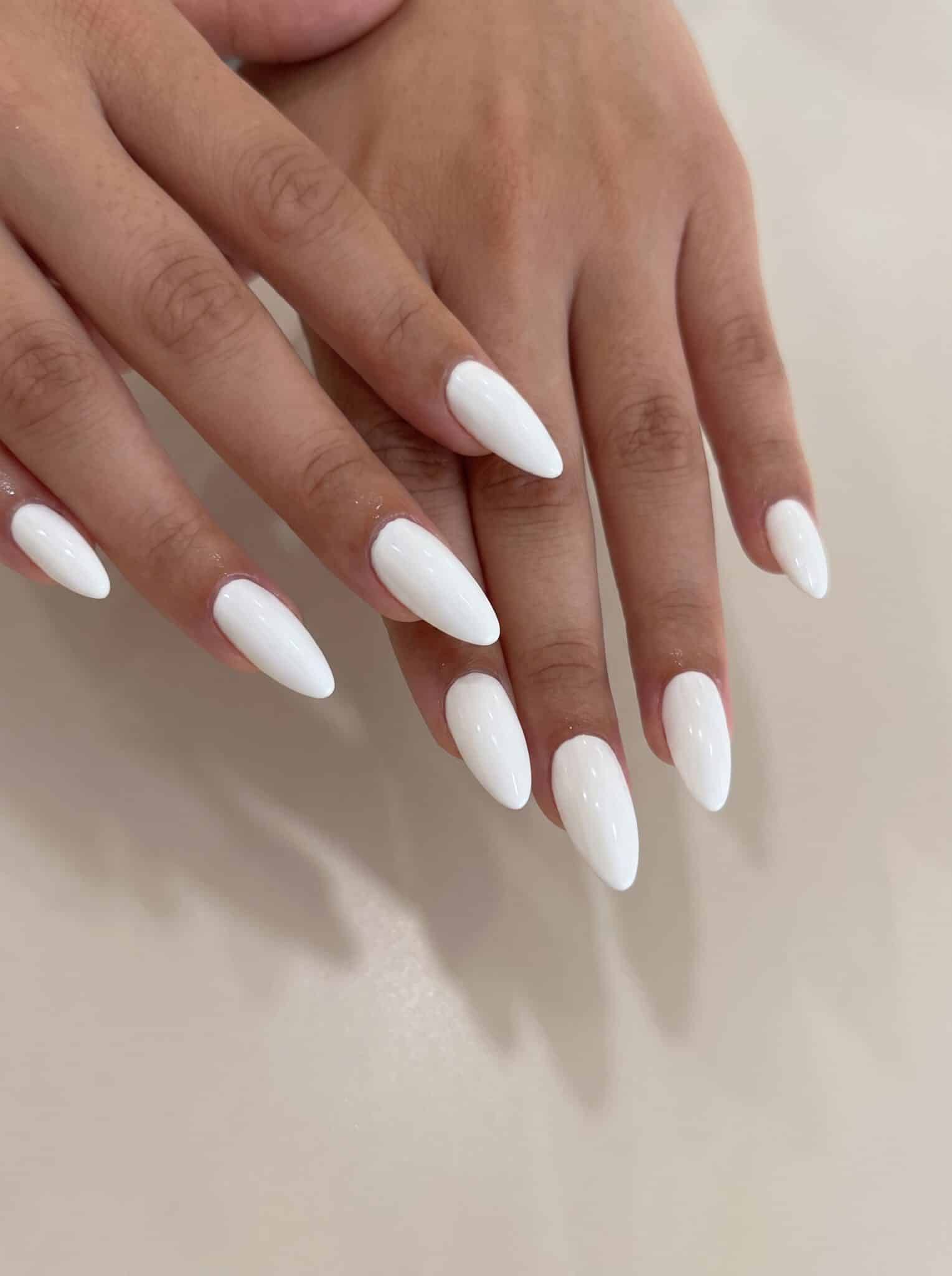 nude hibiscus neutral nails with milky pink base and white flower accents