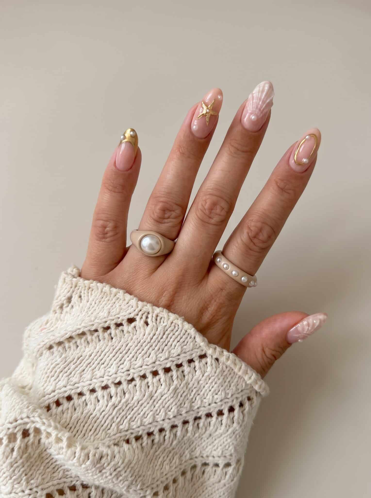 pearl half shell neutral nails with milky pink base and pearl decals