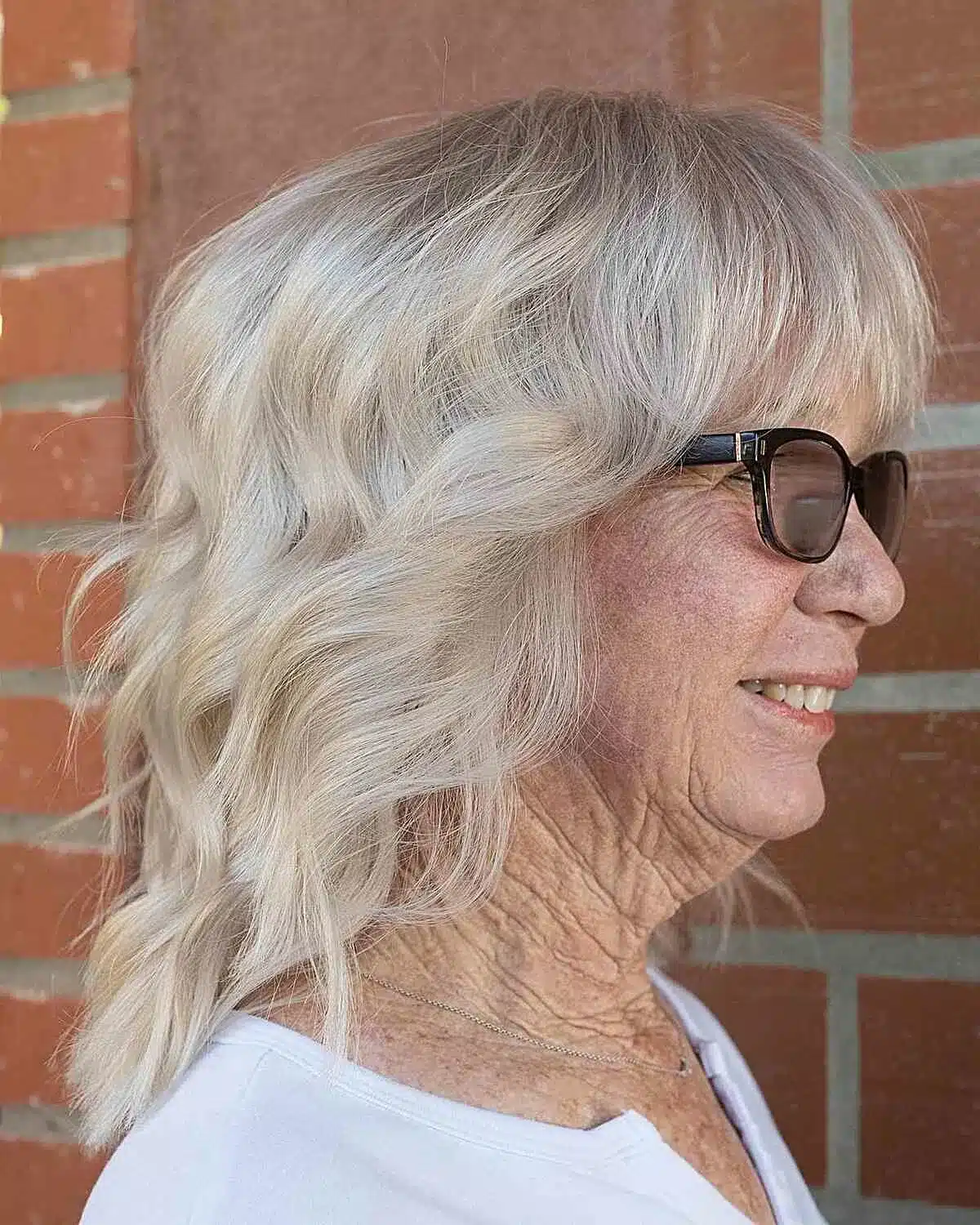 Edgy Mid-Length Platinum Wavy Shag with Wispy Bangs for Grandmas Over 70